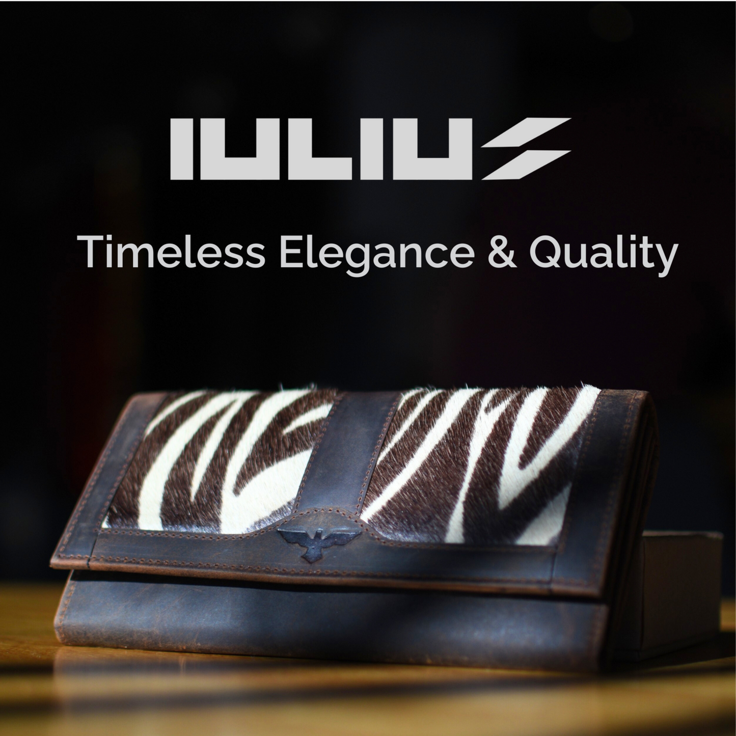 Cartera IULIUS sobre mesa de madera con fondo oscuro y logo visible – Elegancia atemporal